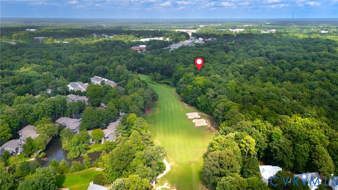 Aerial view showcasing expansive grounds with manicured lawn, mature tree canopy, and multiple residential structures nestled throughout lush landscape