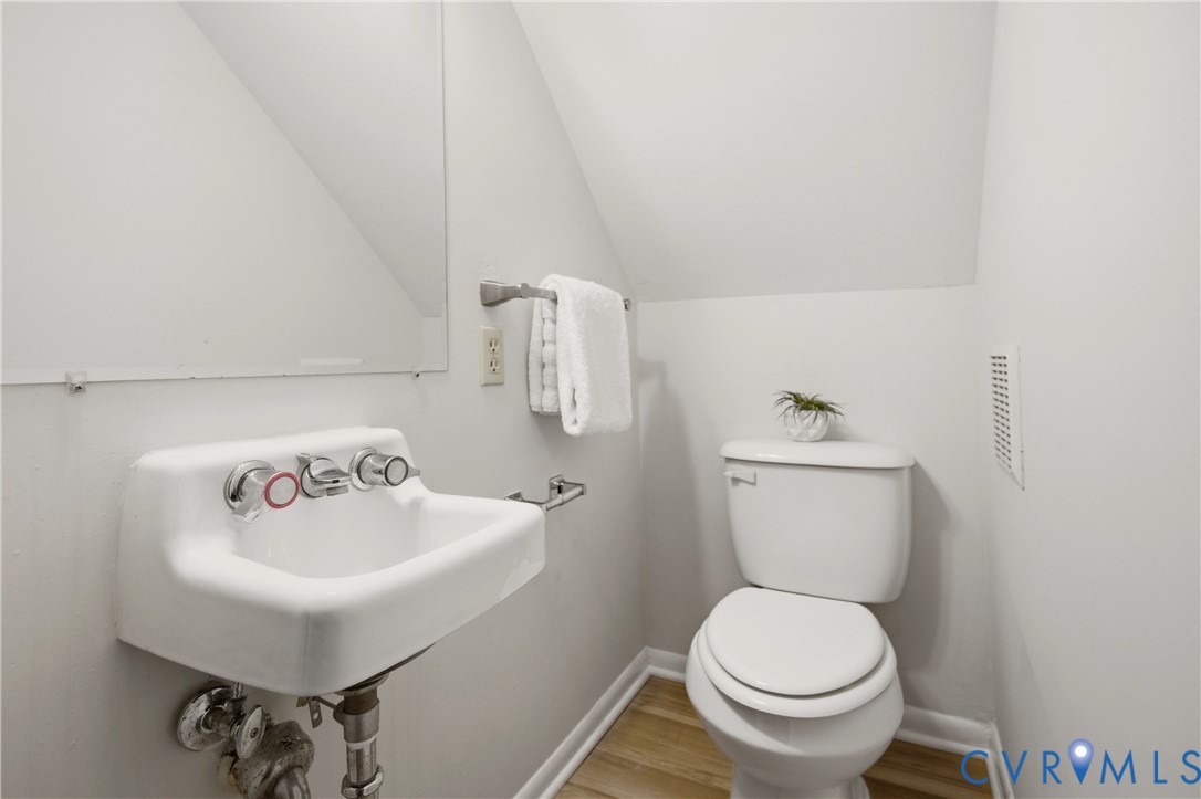 Compact bathroom featuring a wall-mounted porcelain sink with chrome fixtures and a white toilet