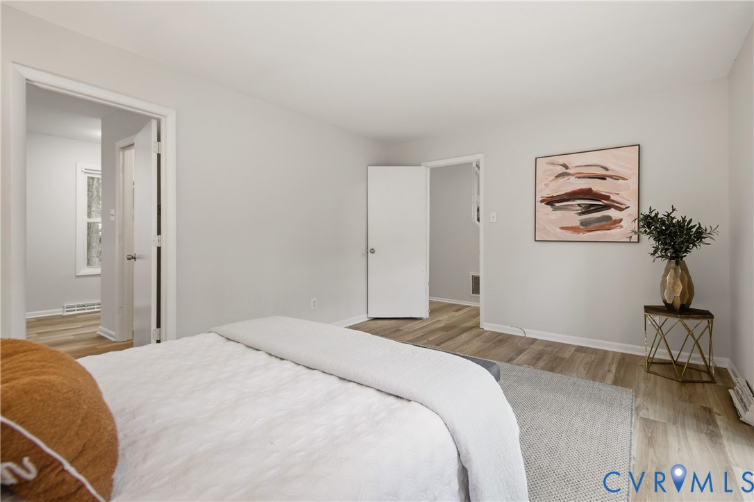 Interior space featuring light wood-finish flooring, light grey wall paint, white trim, and white doors