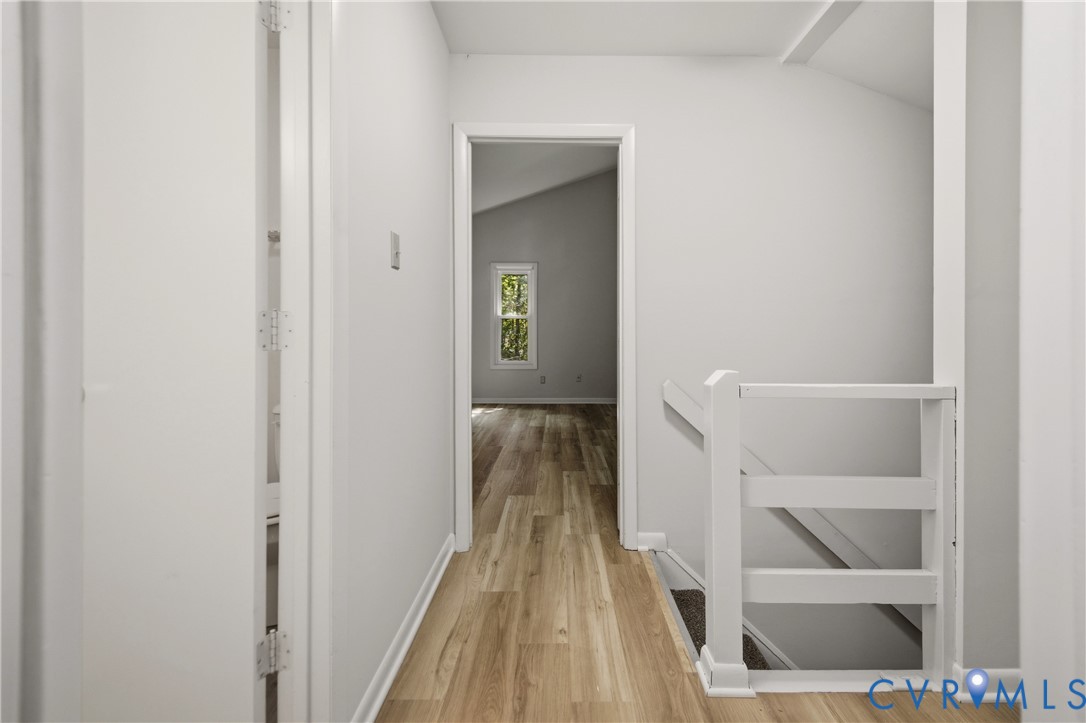 Bright hallway with wood-finish flooring, white painted walls, and clean architectural lines