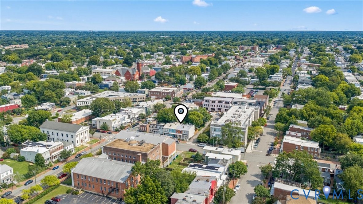 Urban neighborhood setting with diverse architectural styles and mature tree canopy