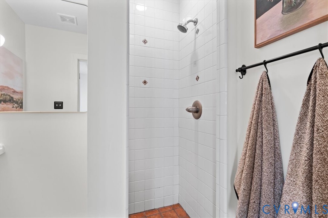Shower with white subway tile surround, accent tiles, and a bronze-finish shower fixture