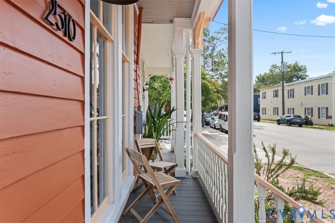 Front porch featuring wood siding, architectural columns, and a railing