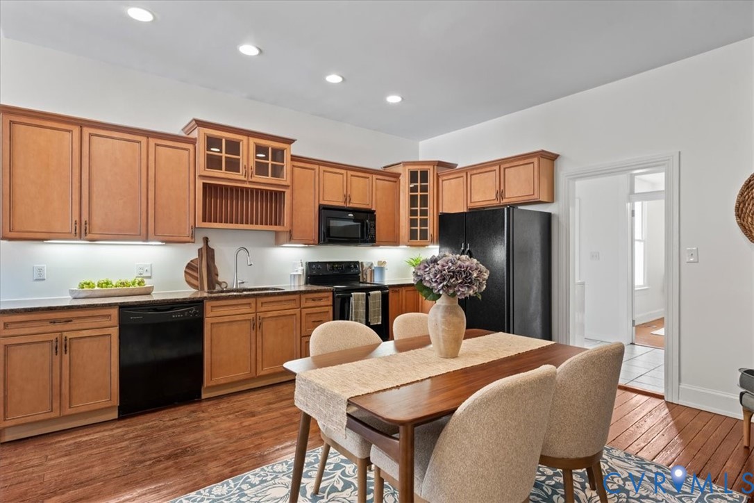 Kitchen featuring wood cabinetry, black appliances, recessed lighting, and wood-finish flooring