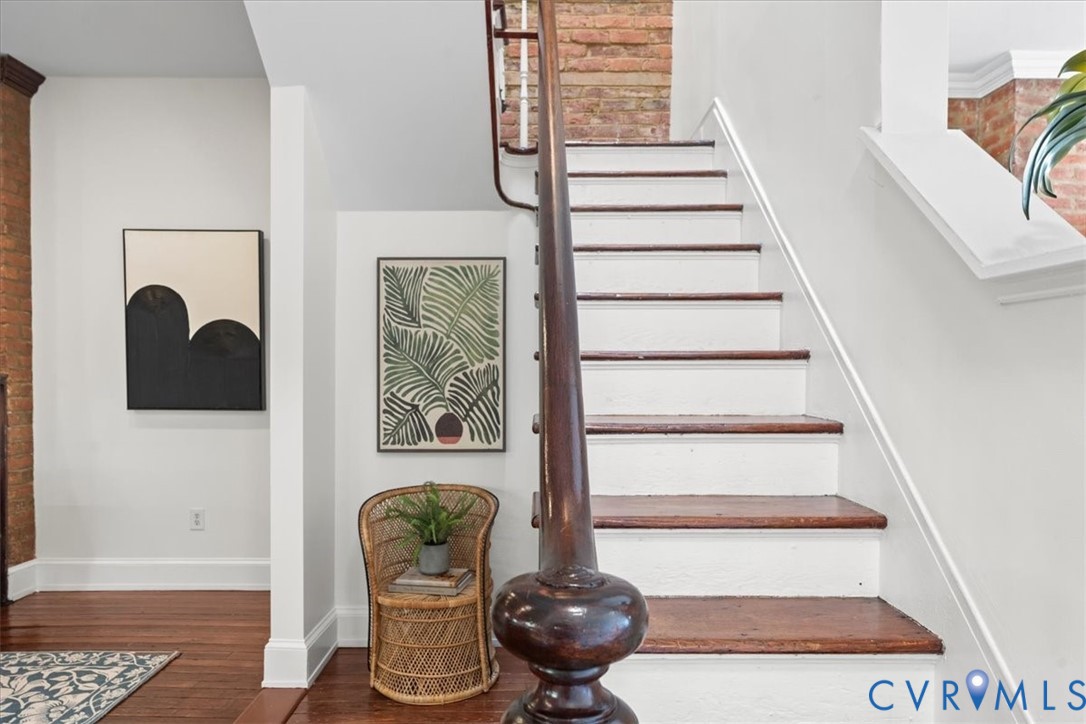 Hardwood flooring, painted risers, wood staircase treads, and a wood newel post with baluster detail