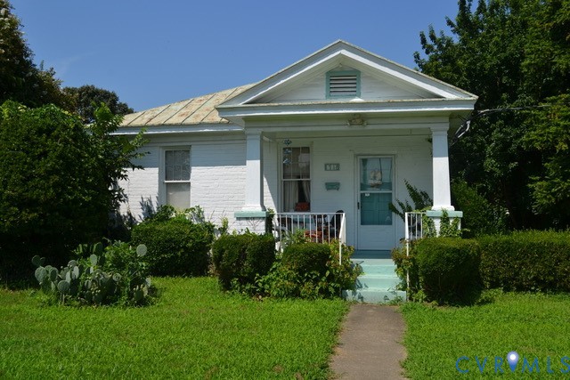 White brick exterior with a pitched roof and a front porch White brick exterior with a pitched roof and a front porch