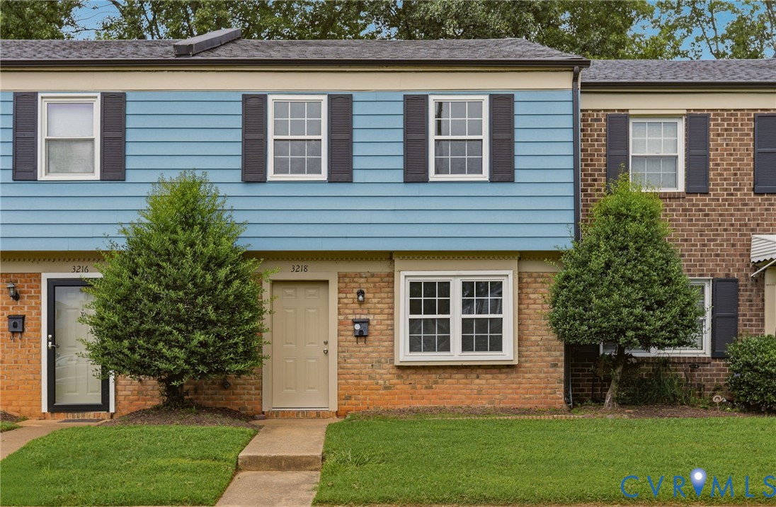 Blue siding facade with white trim and dark window shutters Blue siding facade with white trim and dark window shutters