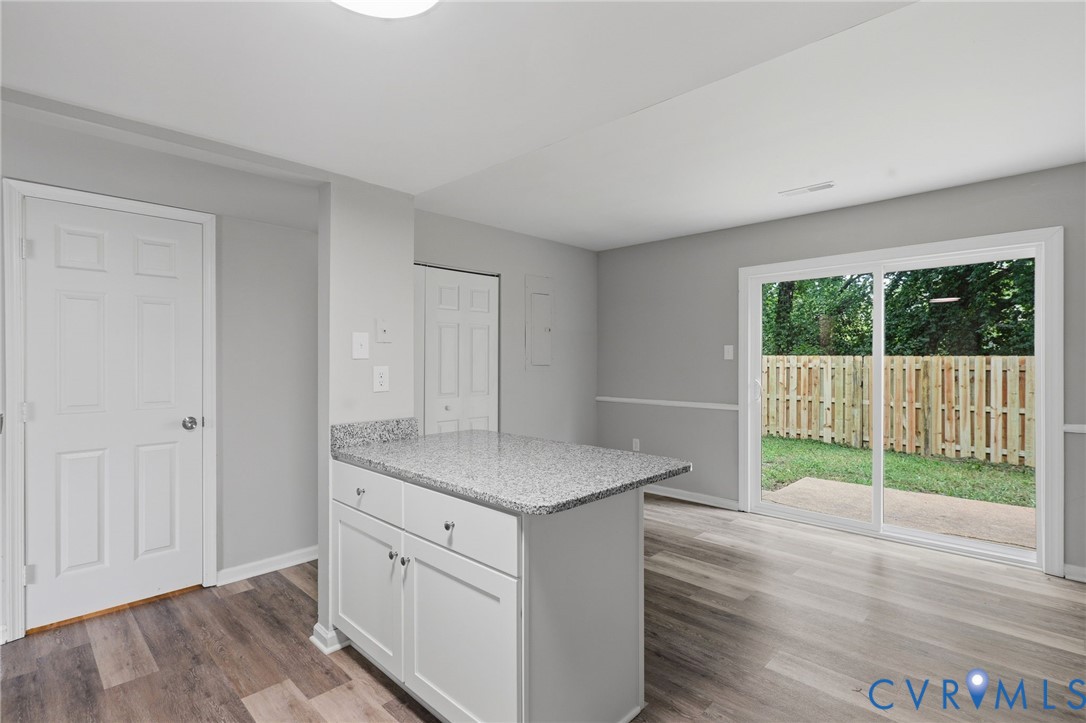 Kitchen island featuring a speckled countertop and white cabinetry