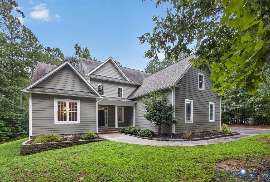 Multi-gabled exterior with siding, white trim windows, and a covered entry Multi-gabled exterior with siding, white trim windows, and a covered entry