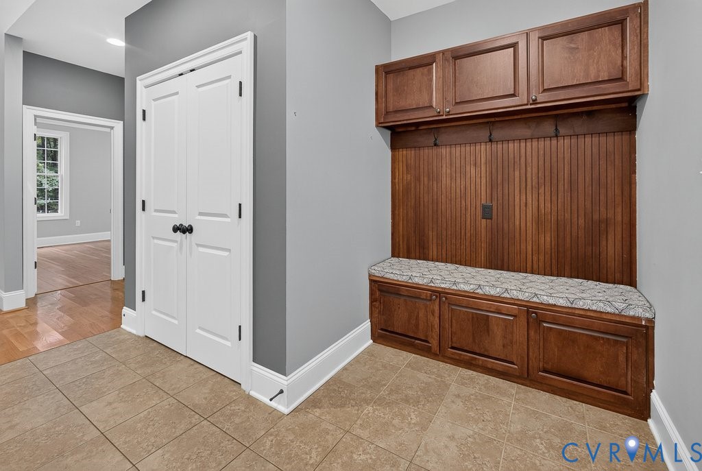 Built-in wood mudroom storage with upper cabinetry and beadboard backing