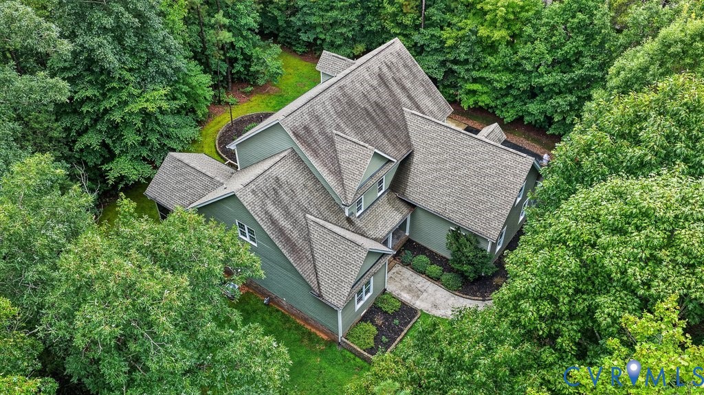 Multi-level roofline with dormer windows, surrounded by mature trees