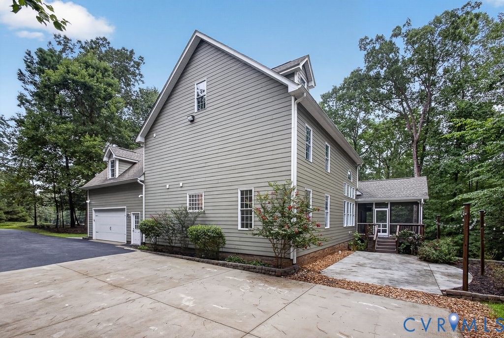 Siding exterior with multiple windows, two-car garage, dormer windows, and a screened porch