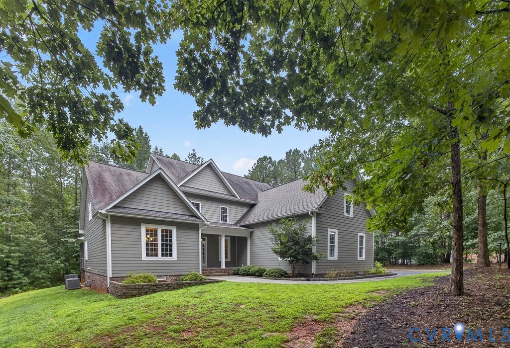 Two-story residential structure with multiple gables, siding exterior, and white-framed windows