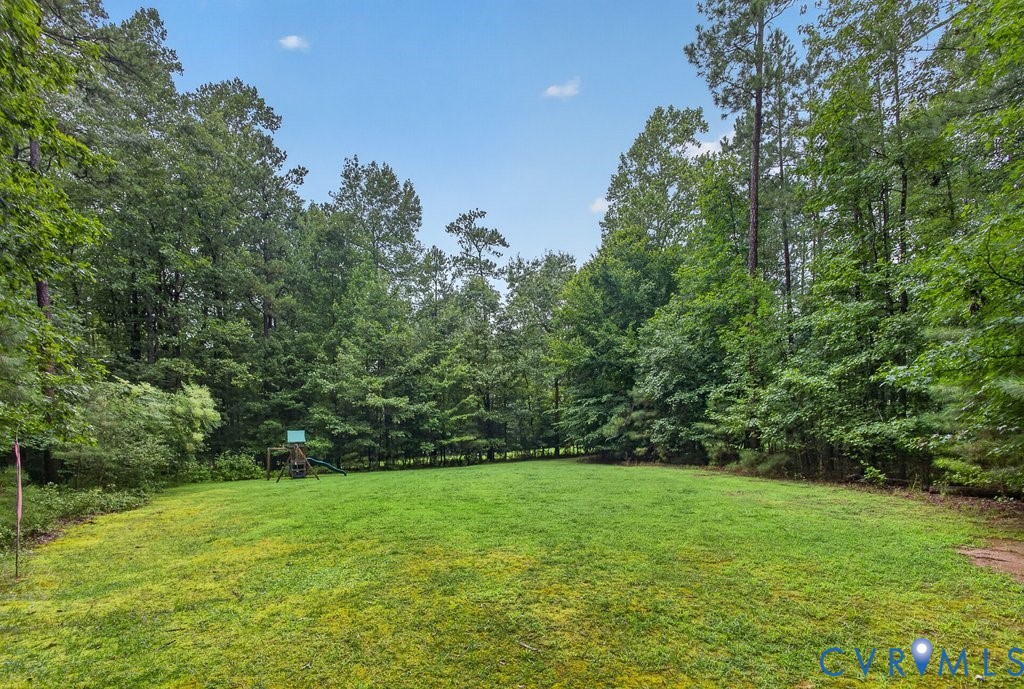 Expansive green lawn surrounded by mature trees