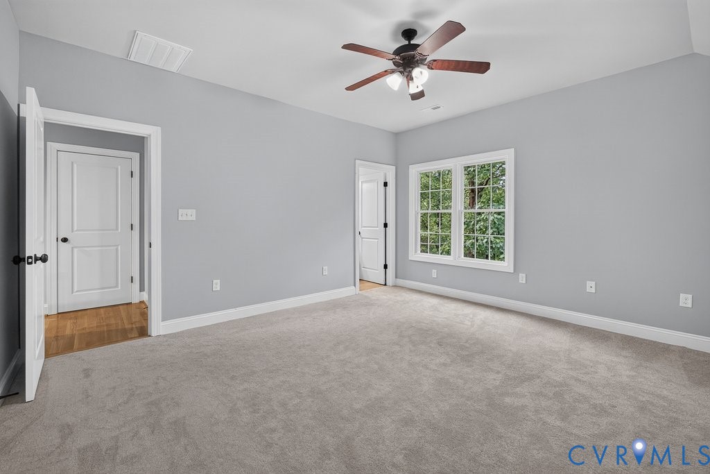 Carpeted room featuring a ceiling fan with integrated lighting, a double casement window, and painted walls