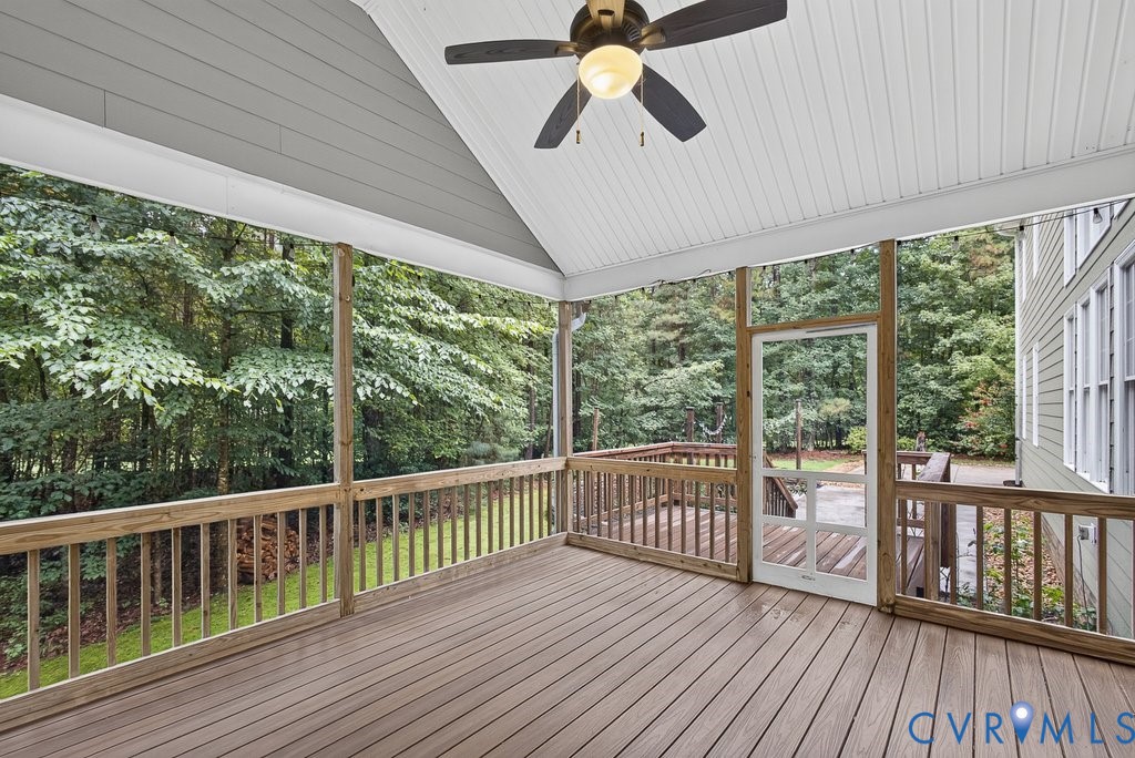 Screened porch with composite decking, vaulted ceiling, and ceiling fan