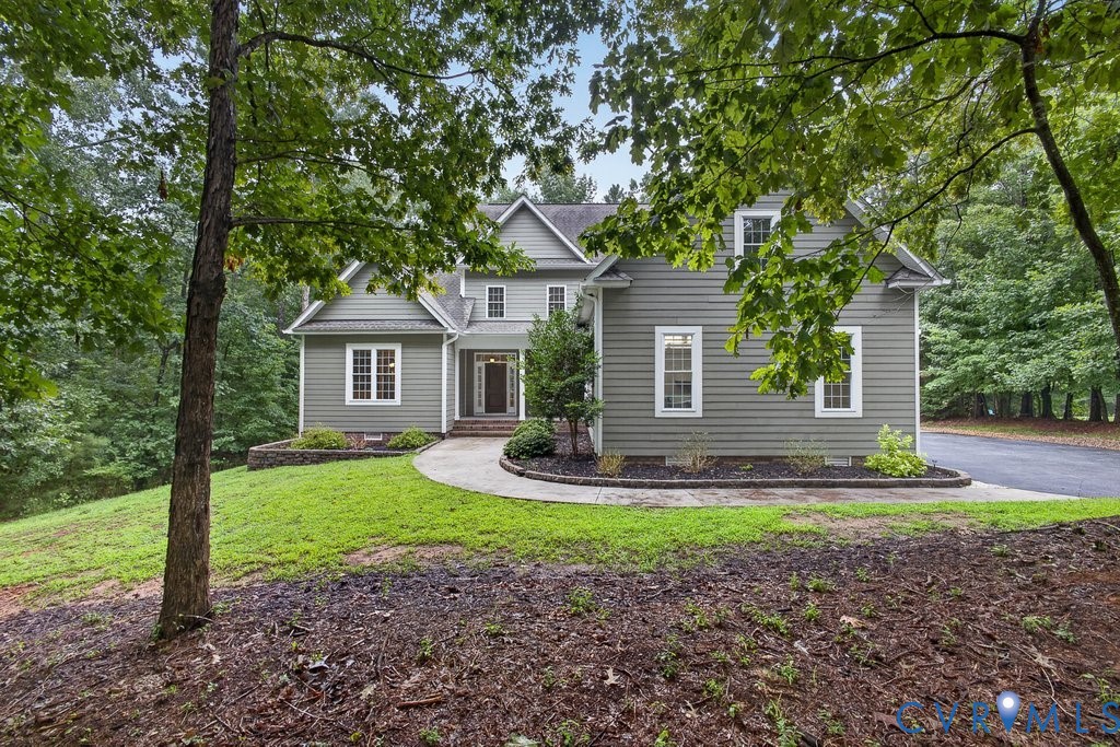 Two-story home with a gabled roofline, siding exterior, and multiple white-framed windows