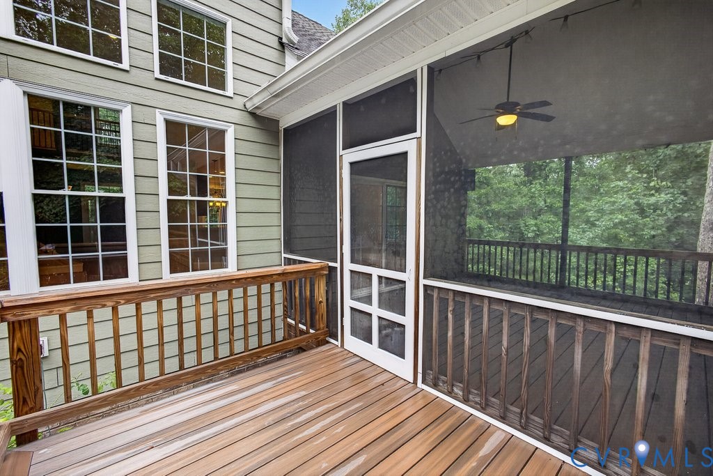 Wood deck with wood railing, screened porch, ceiling fan, and horizontal siding