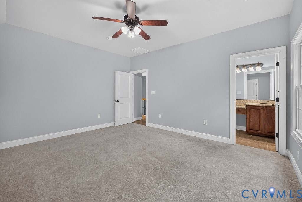 Carpeted room with a ceiling fan and light fixture, featuring light gray walls and white trim