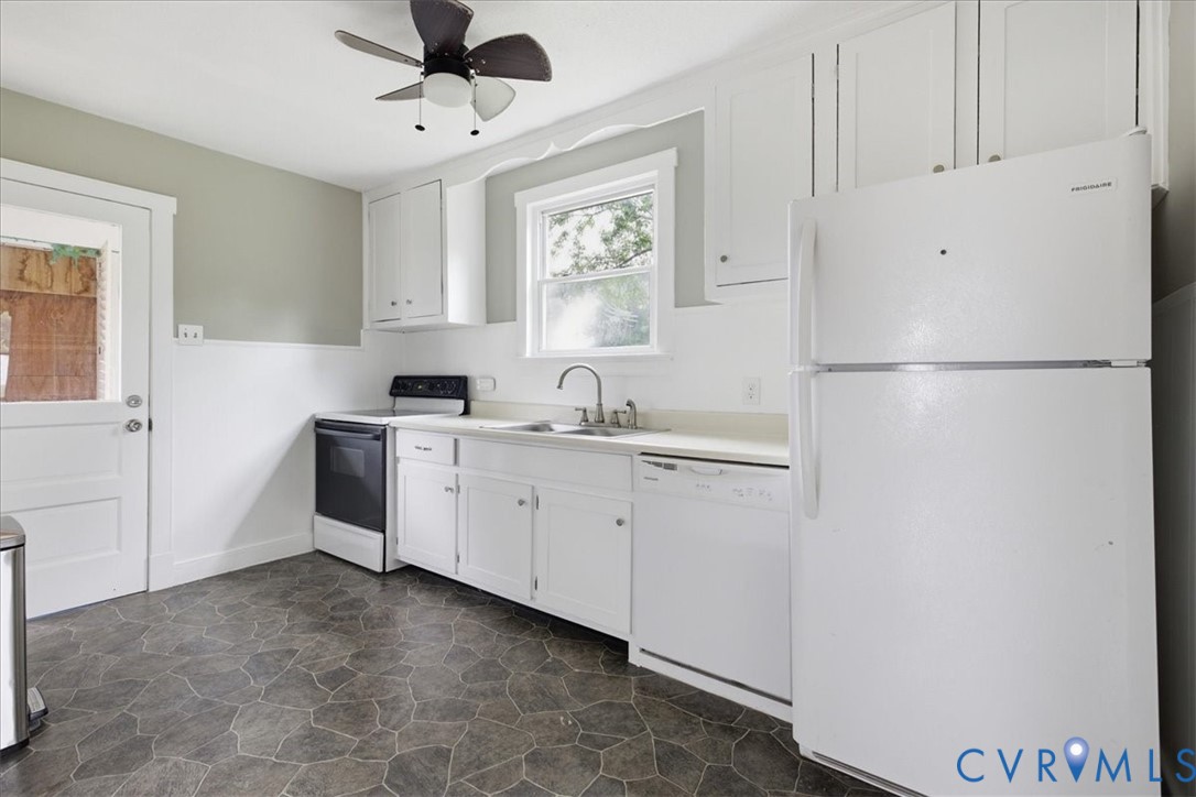 Kitchen featuring white cabinetry, a top-freezer refrigerator, dishwasher, and an electric range