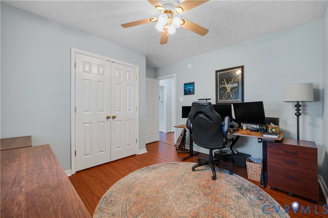 Bedroom Two featuring Wood-finish flooring, ceiling fan with integrated lighting, paneled bifold closet doors