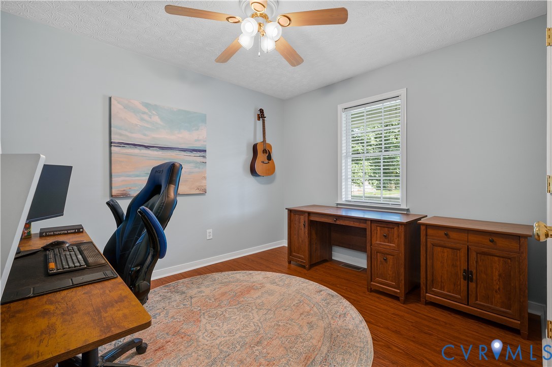 Bedroom Two featuring hardwood flooring, a ceiling fan with light, large closet, and window