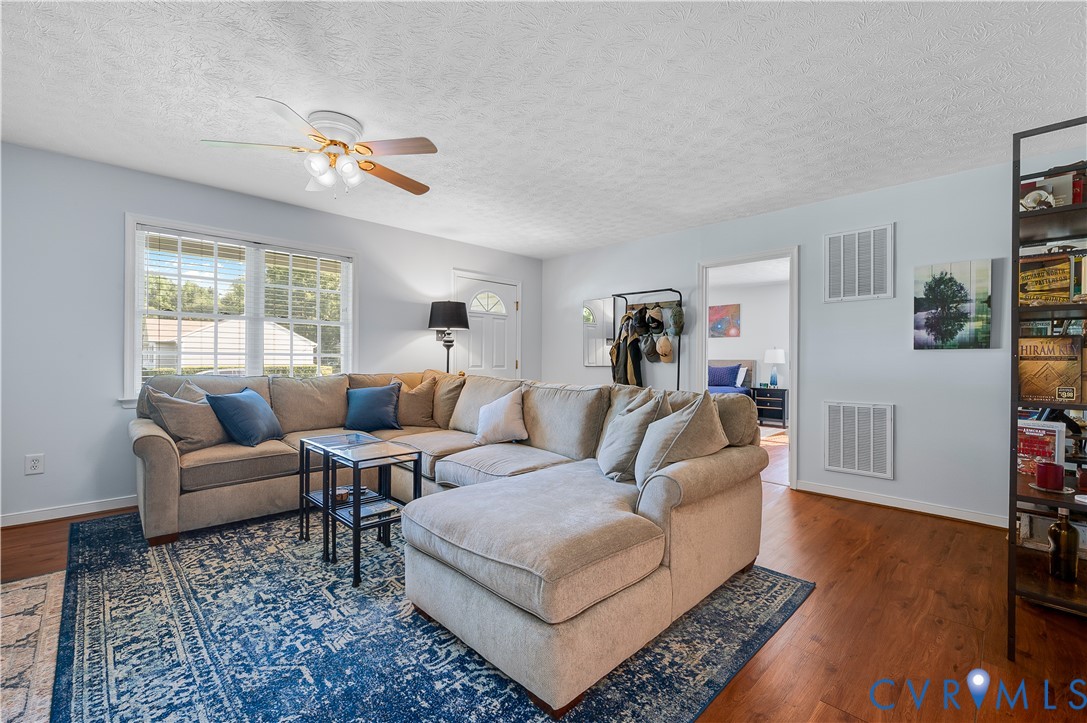 Spacious living room anchored by hardwood flooring and abundant natural light from multi-pane windows Spacious living room anchored by hardwood flooring and abundant natural light from multi-pane windows