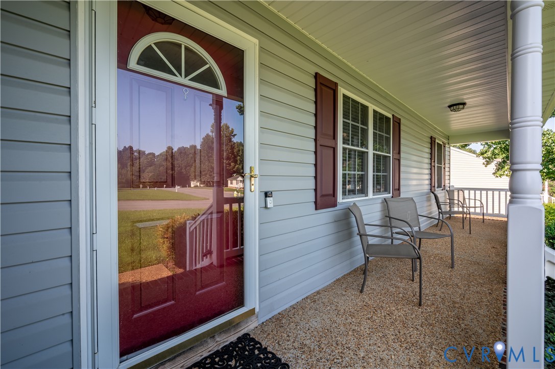 Covered front porch featuring light gray siding and textured flooring Covered front porch featuring light gray siding and textured flooring