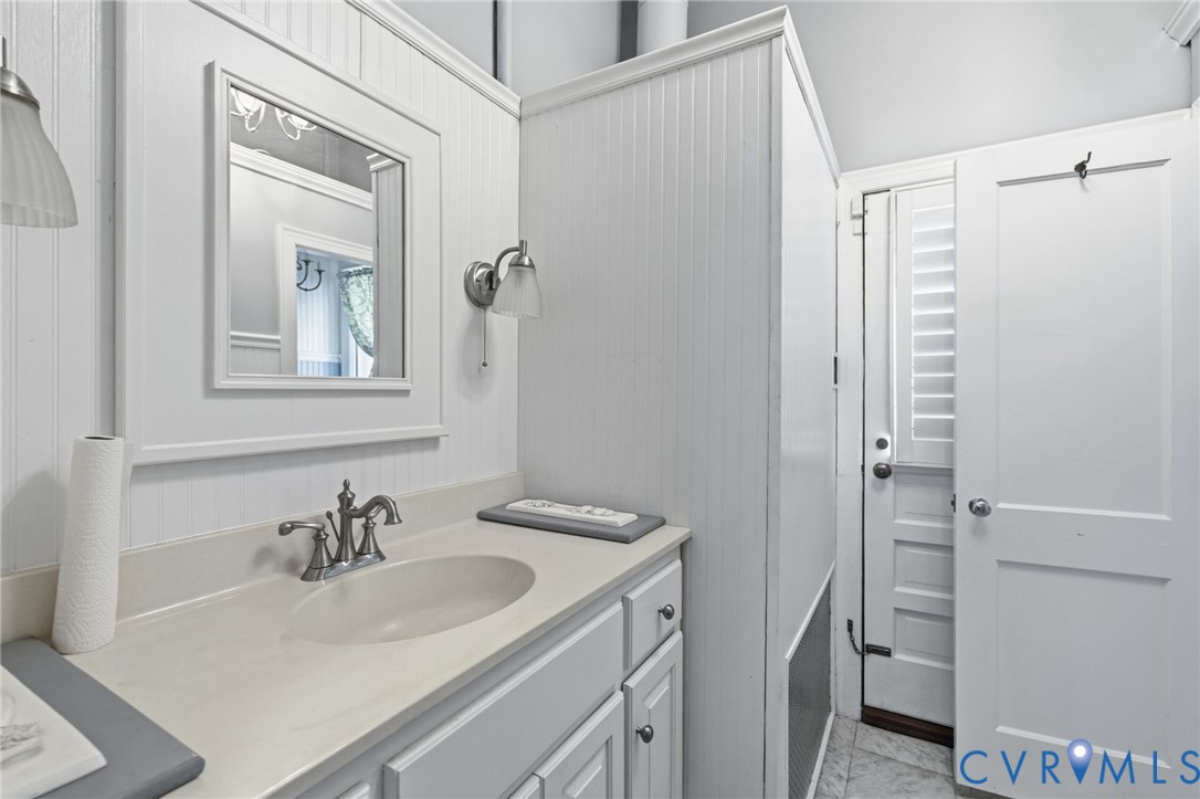 White vanity with a single basin sink and brushed nickel faucet