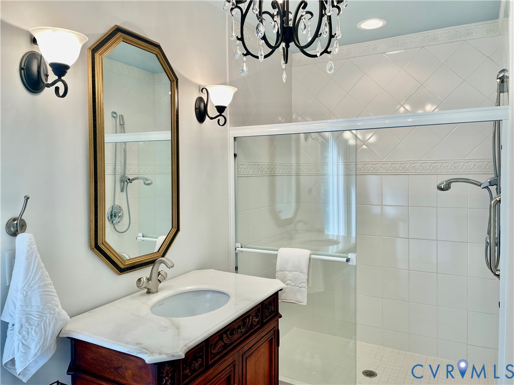 Walk-in shower with glass enclosure and tiled surround