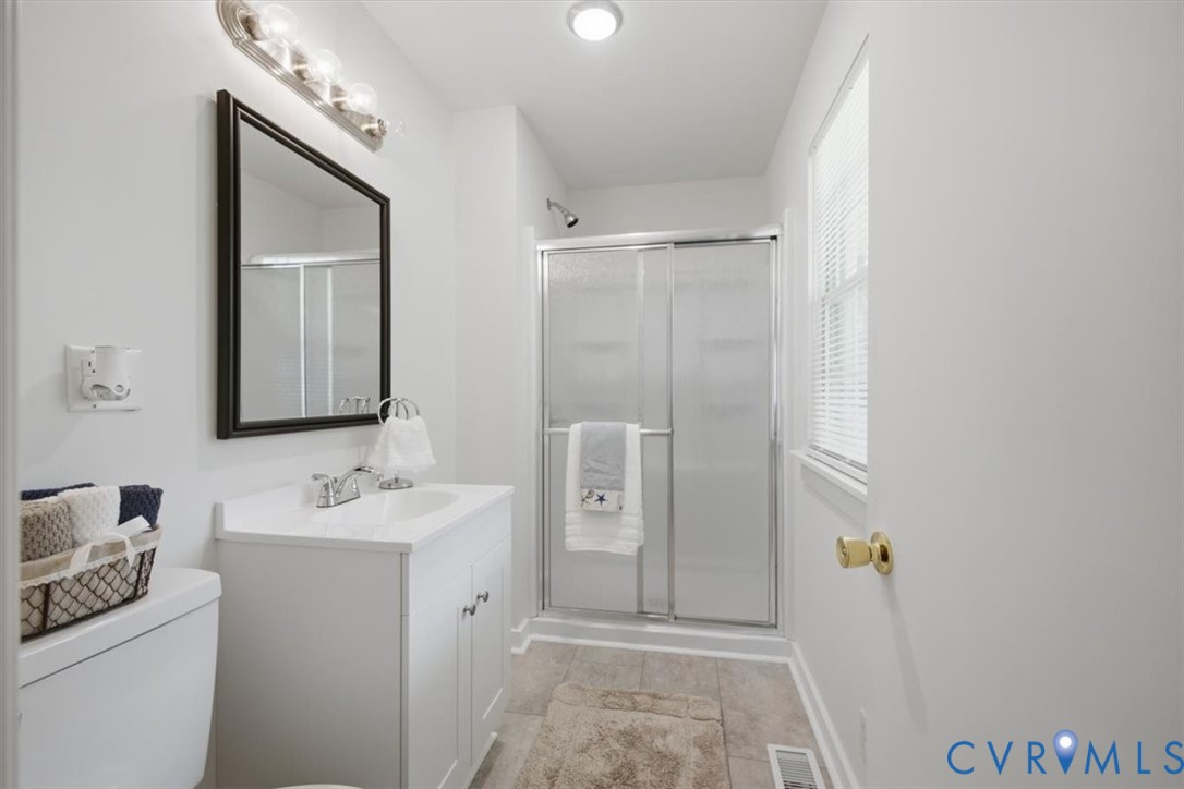 White vanity with integrated sink, chrome faucet, and framed mirror