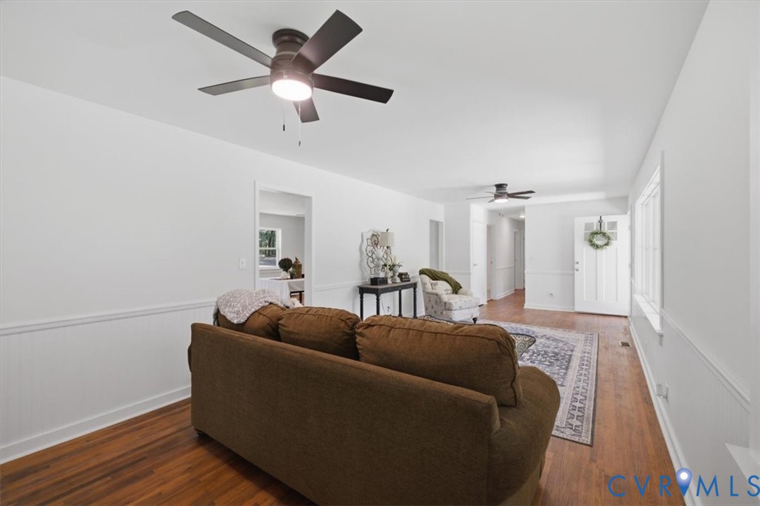 Hardwood flooring, white wainscoting, recessed lighting, and ceiling fans