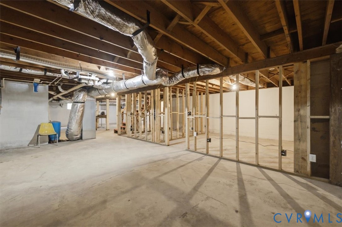 Unfinished basement featuring exposed wood joists and concrete flooring