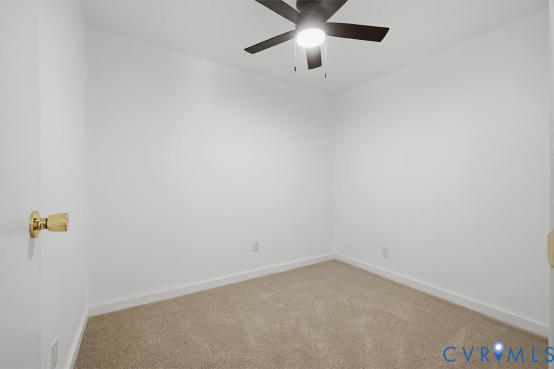 Neutral wall color, carpeted flooring, and a ceiling fan with integrated lighting