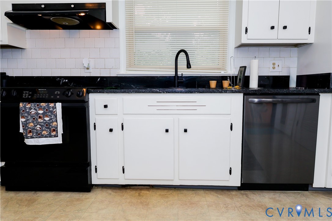 White cabinetry with black hardware, granite countertops, built-in range, and dishwasher White cabinetry with black hardware, granite countertops, built-in range, and dishwasher