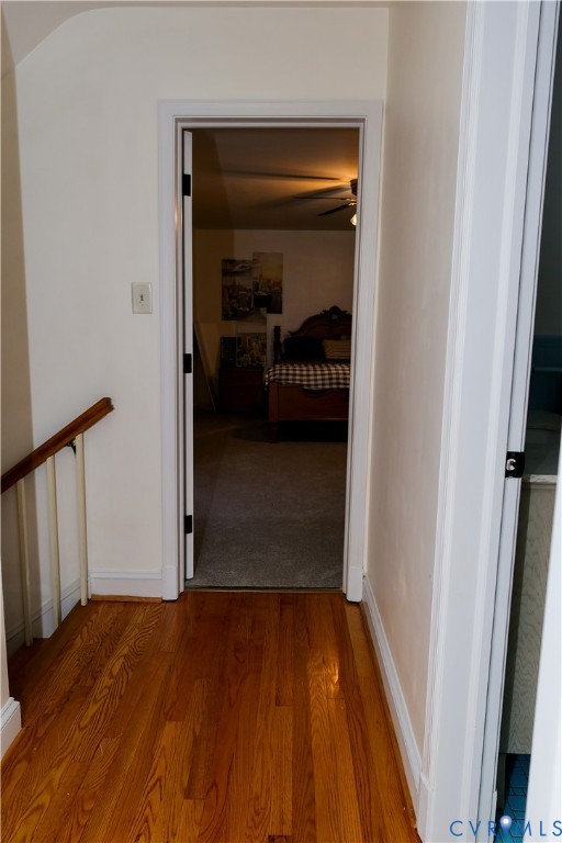 Second floor landing w/ Wood-finish flooring with a wood handrail