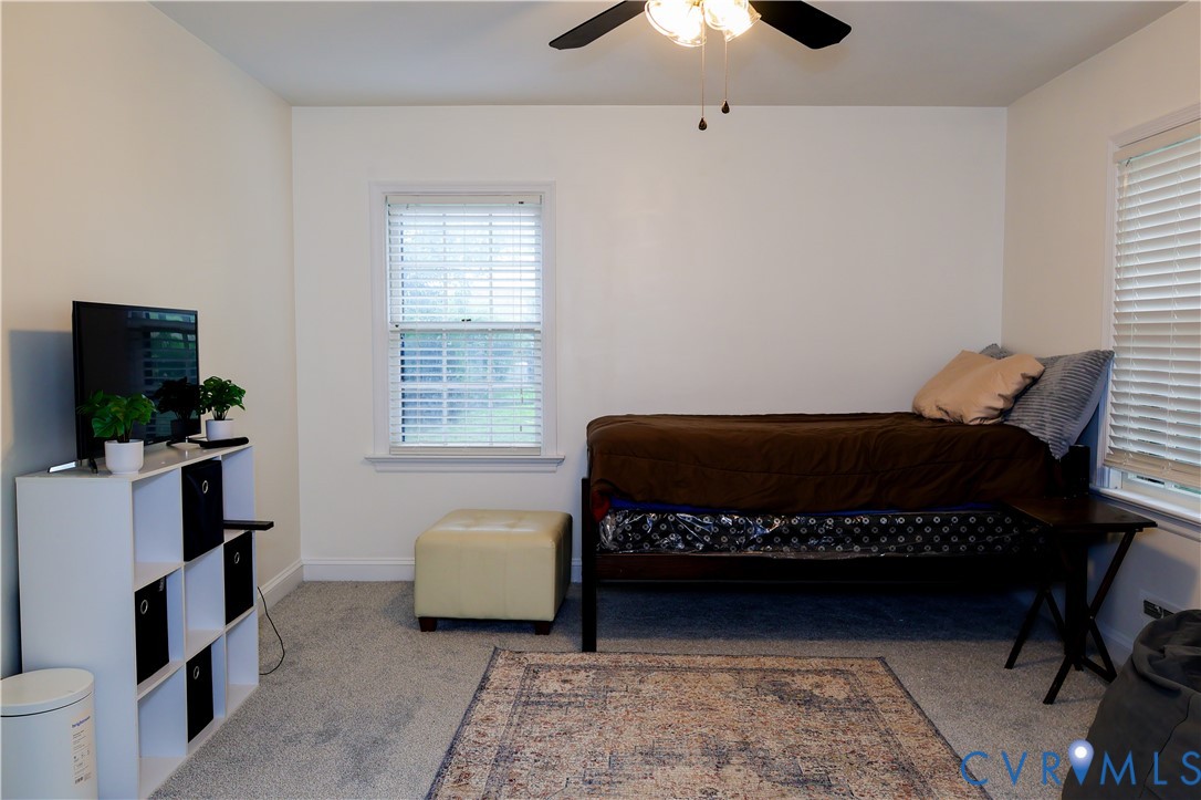 Downstairs Bedroom 1, ceiling fan with light fixture, carpet flooring