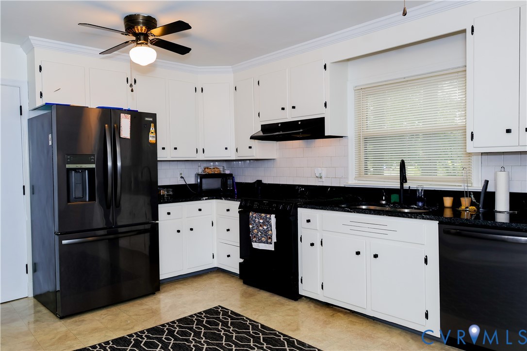 White cabinetry with black hardware, black countertops, and a white subway tile backsplash White cabinetry with black hardware, black countertops, and a white subway tile backsplash