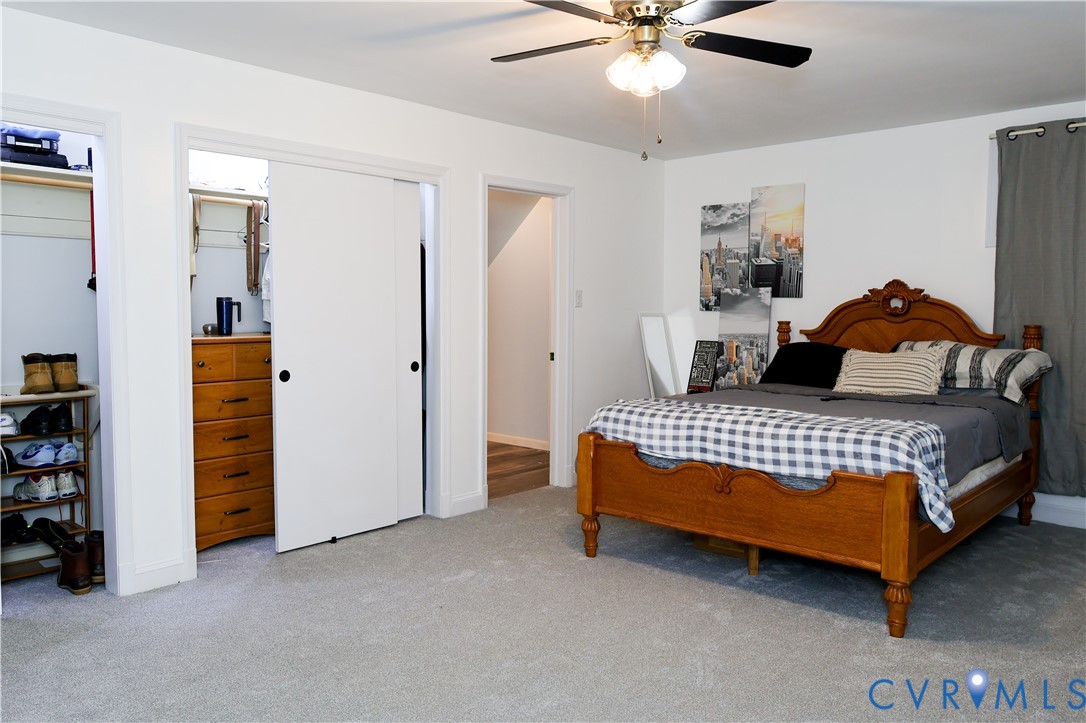 Built-in ceiling fan with light fixture, light, carpeting, and a closet with sliding doors