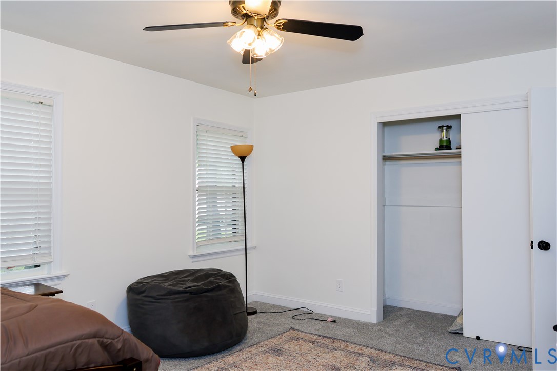 Downstairs Bedroom 1, a ceiling fan with integrated lighting, closet with sliding doors.
