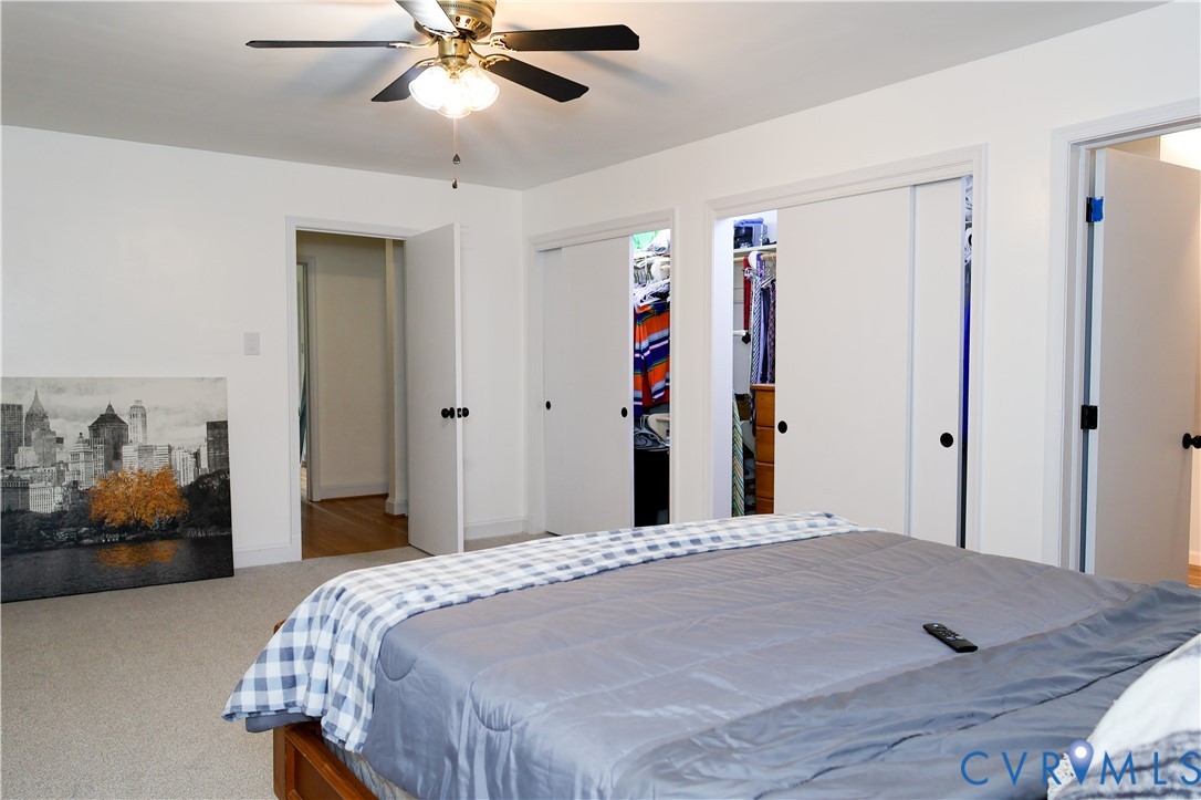 Recessed lighting with a ceiling fan, carpeted flooring, and multiple closet spaces with sliding doors