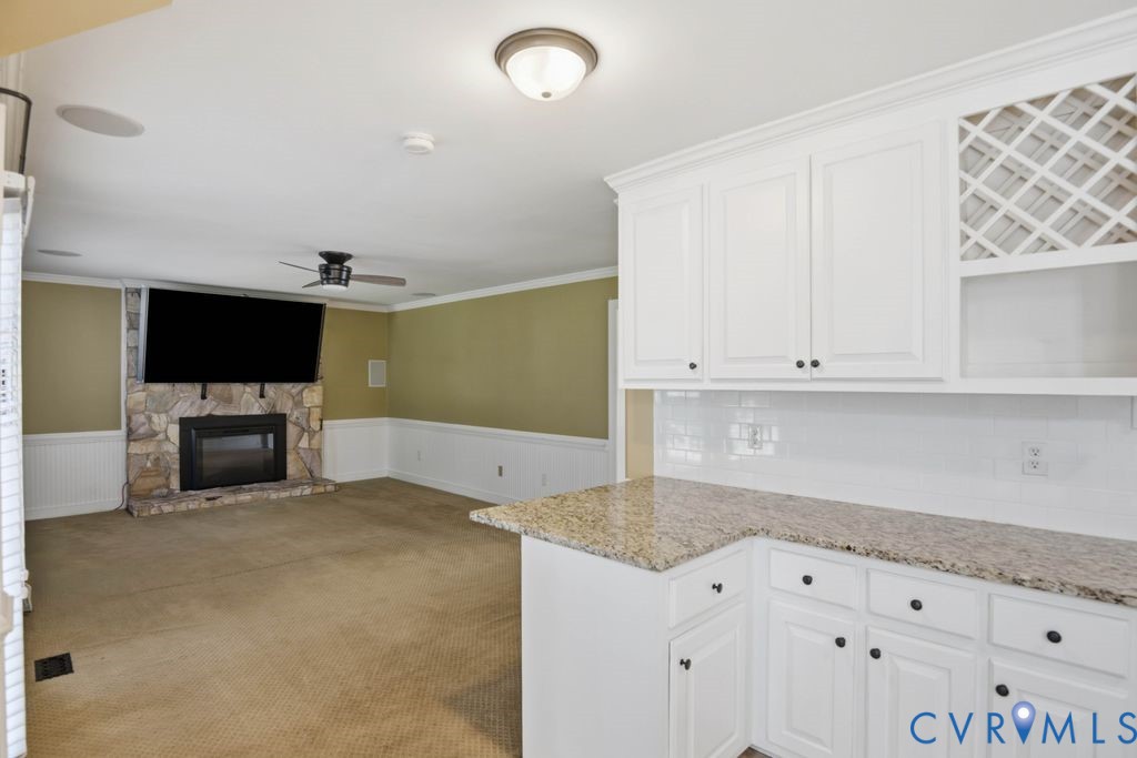 White cabinetry with a lattice wine rack, solid surface countertop, and subway tile backsplash