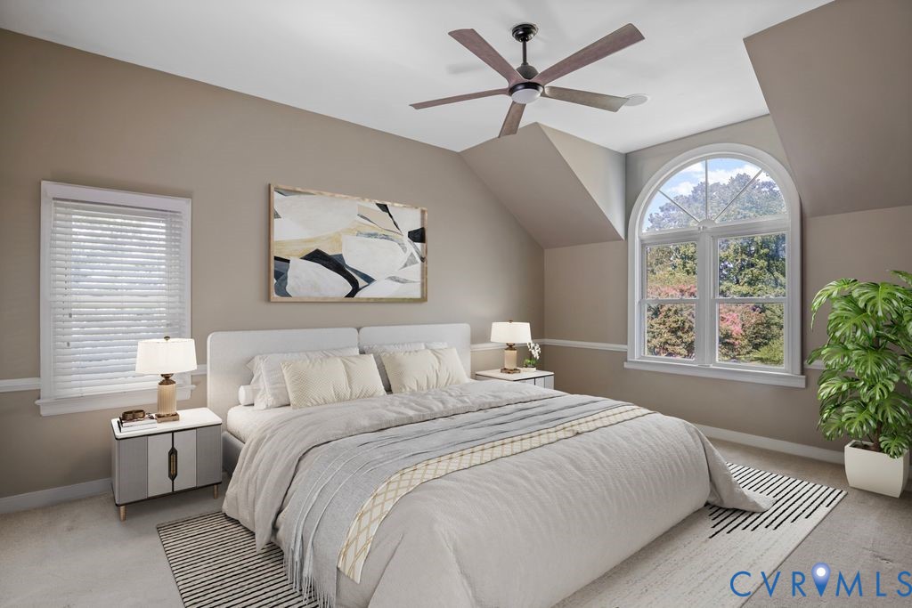 Arched window, second window with blinds, ceiling fan, neutral wall tones, and carpeted flooring