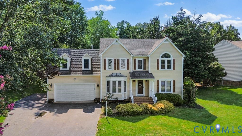 Traditional two-story residence with a two-car garage, bay window, and arched window accent