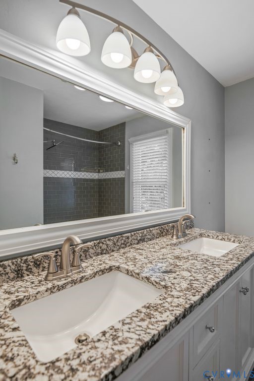 Double vanity with granite-style countertop, dual undermount sinks, and brushed nickel fixtures