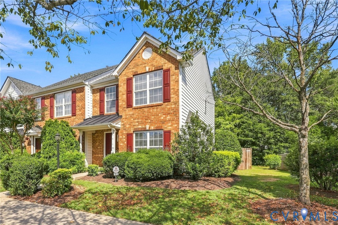 Brick and siding exterior with red shutters, a gabled roofline, and mature landscaping Brick and siding exterior with red shutters, a gabled roofline, and mature landscaping