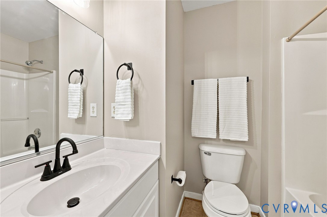 Bathroom featuring tub/shower combo, a built-in vanity with an integrated sink, black-finish faucet, and a large wall-mounted mirror