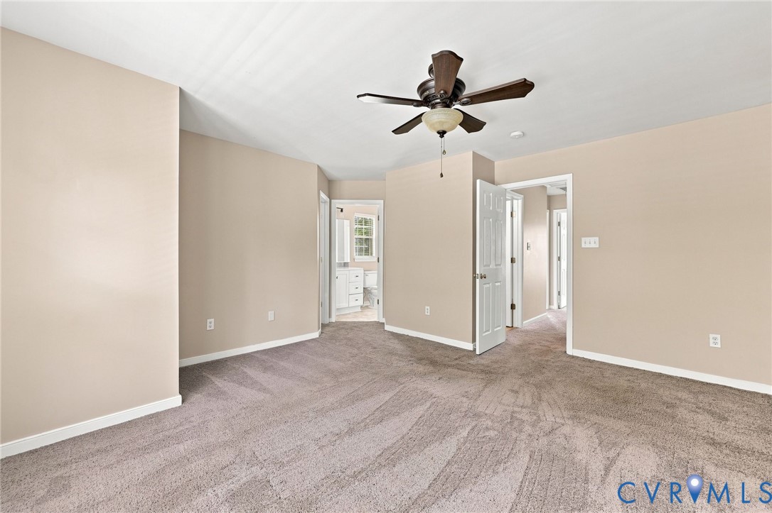Carpeted room with a ceiling fan, light neutral wall paint, and white trim
