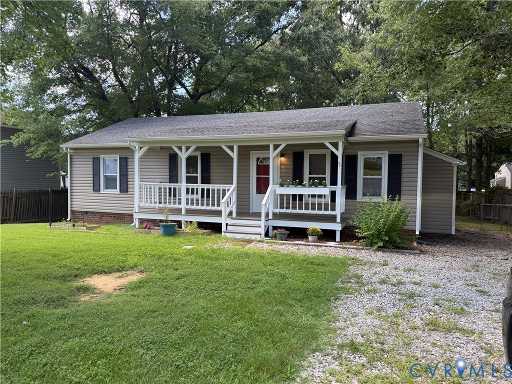 Front exterior featuring a covered porch with white railings, tan horizontal siding, and dark shutters Front exterior featuring a covered porch with white railings, tan horizontal siding, and dark shutters