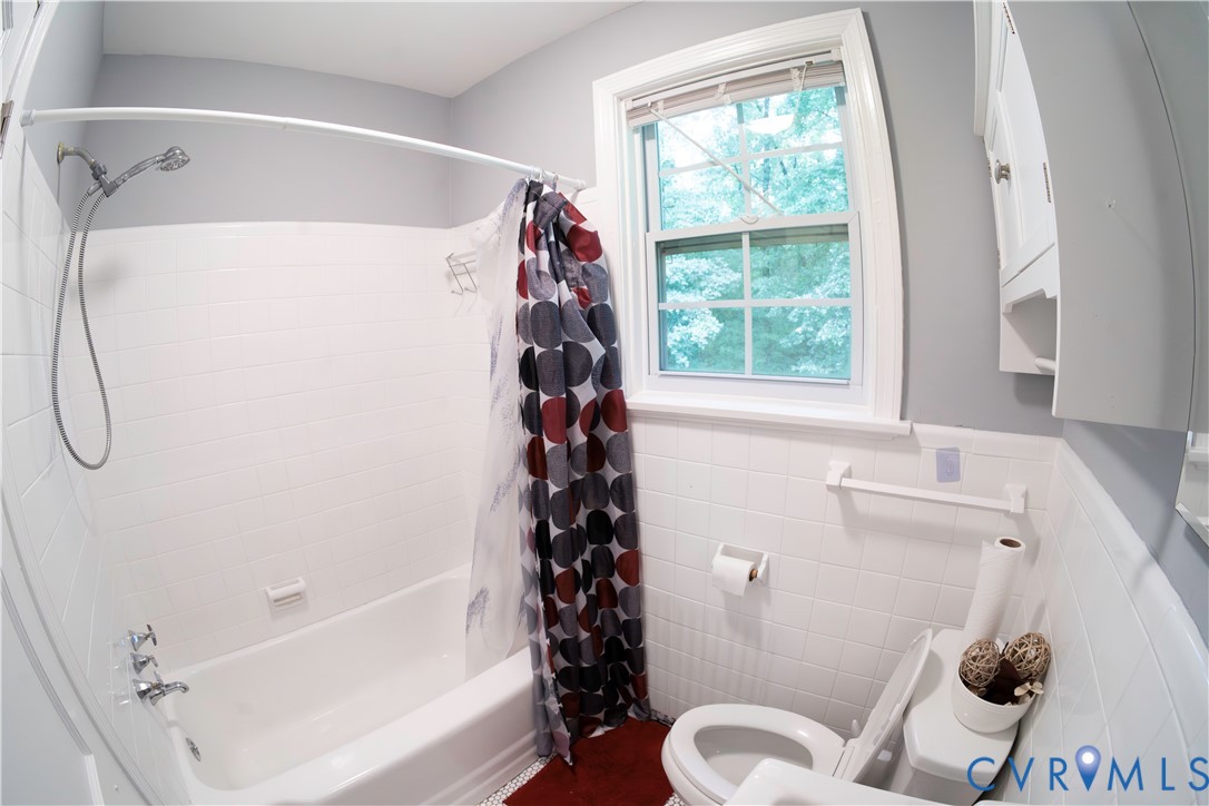 White tiled shower and bathtub combination with a chrome shower fixture